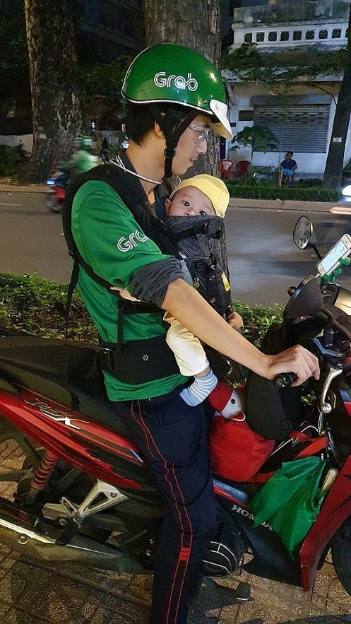 grabbike driver takes 8 month old son to work amid 38c heatwave in sai gon